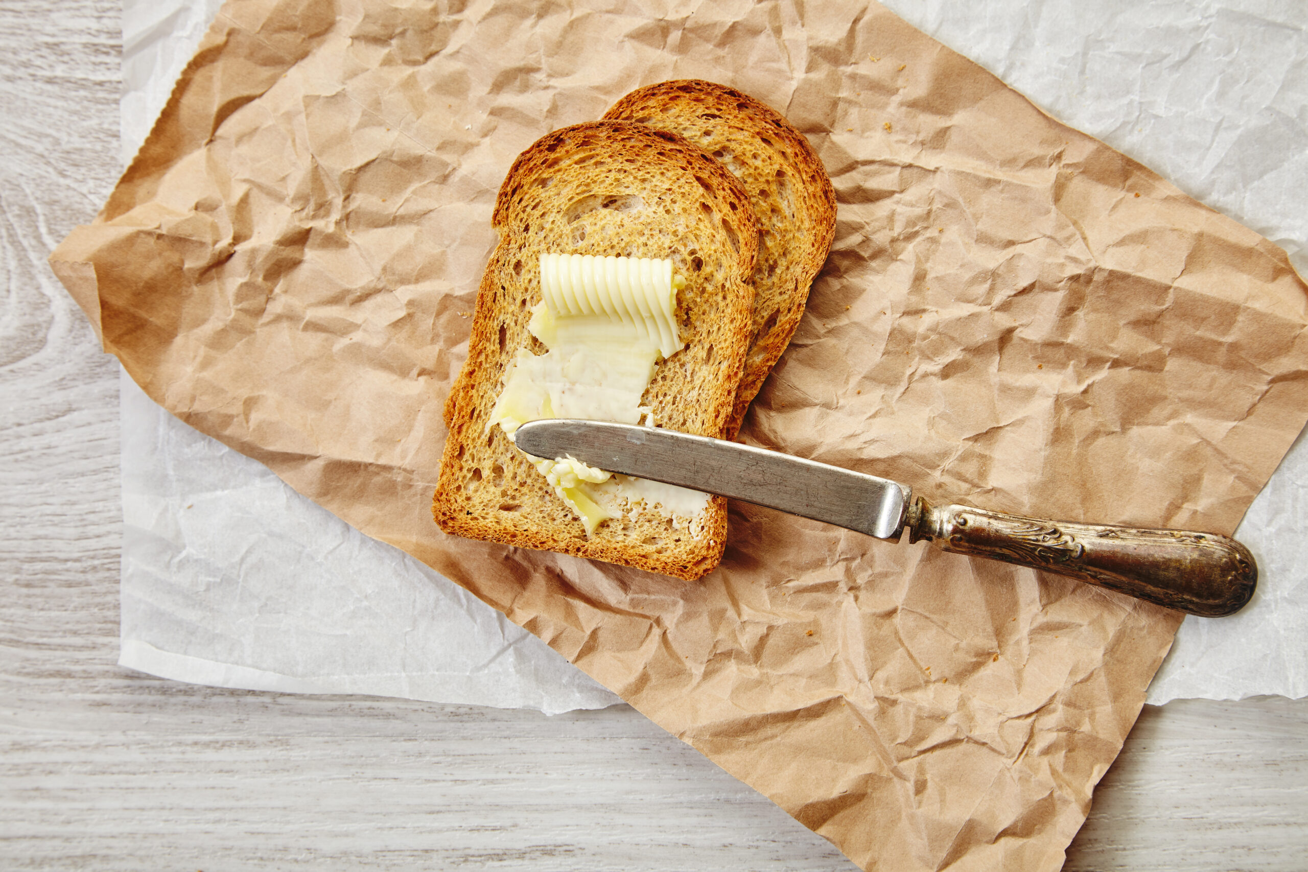 Slices of rye dry bread with butter for breakfast